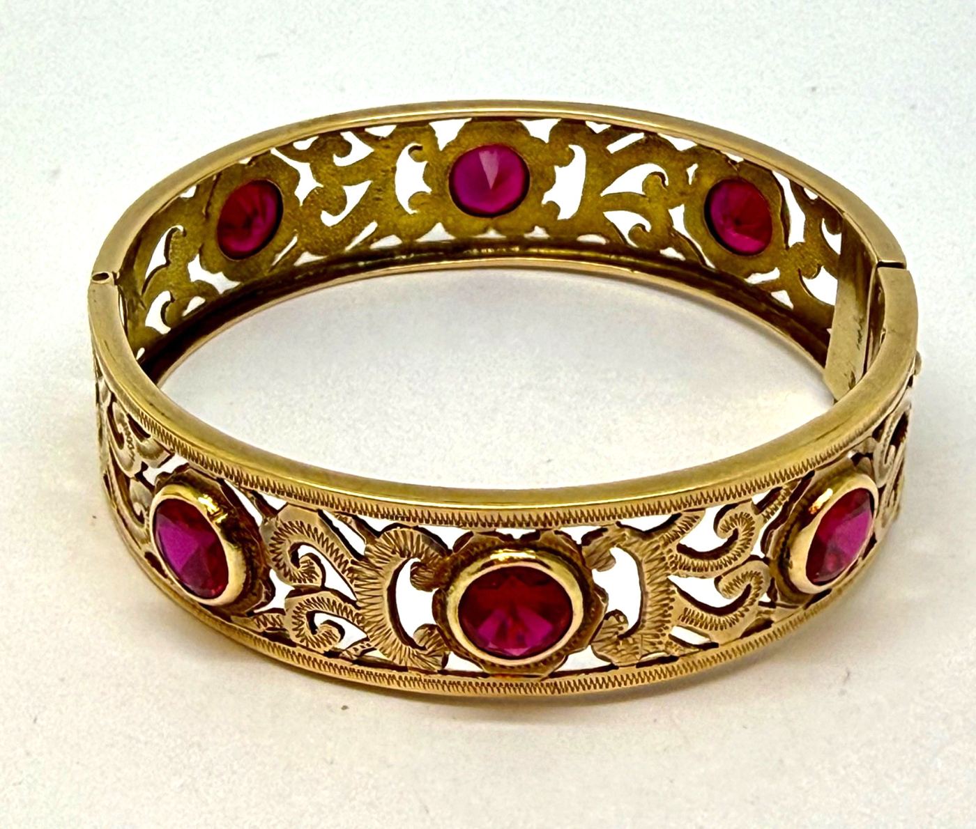 A Victorian 10k yellow gold hinged bangle set with rubies