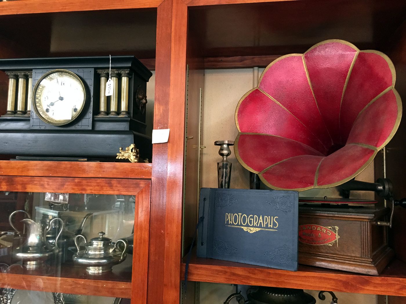 Antique mantel clock, gramophone and silver in a wood display cabinet