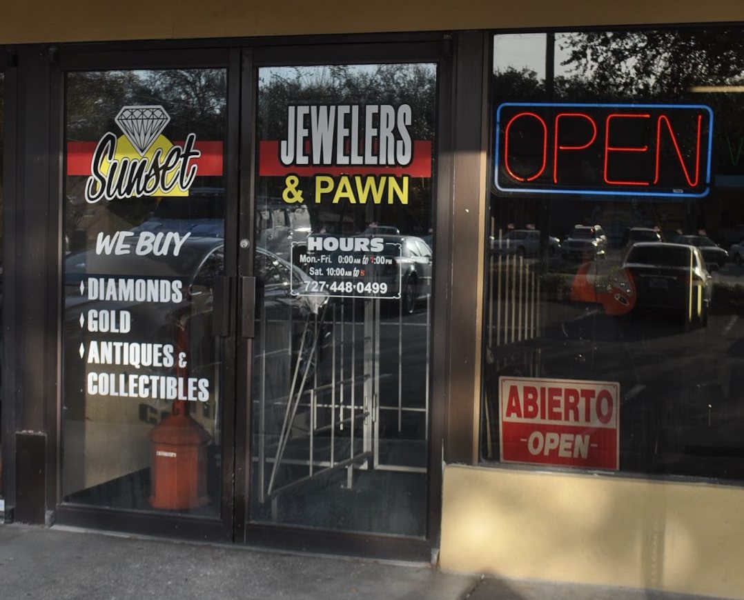 The Sunset Jewelry & Loan storefront with the Sunset logo on the glass doors